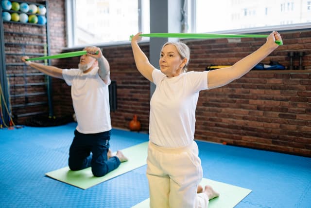 Older adults doing resistance-band strength work in a gym